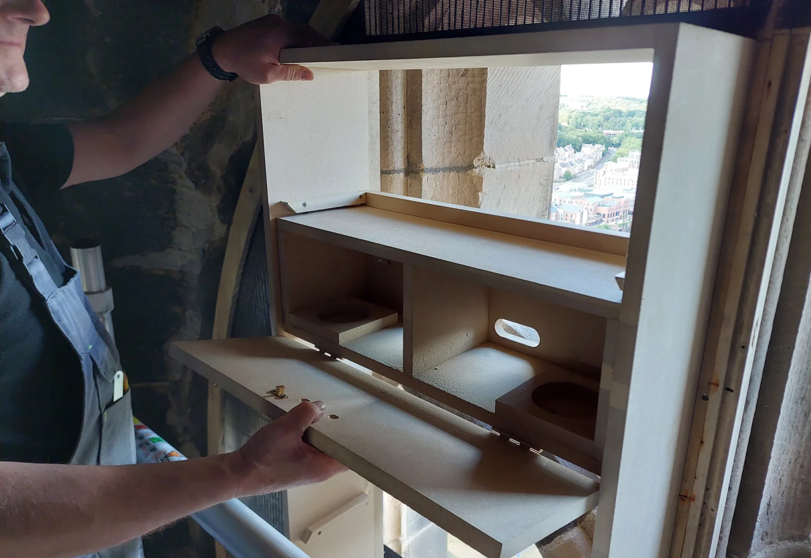 Builder adding swift box to tower window