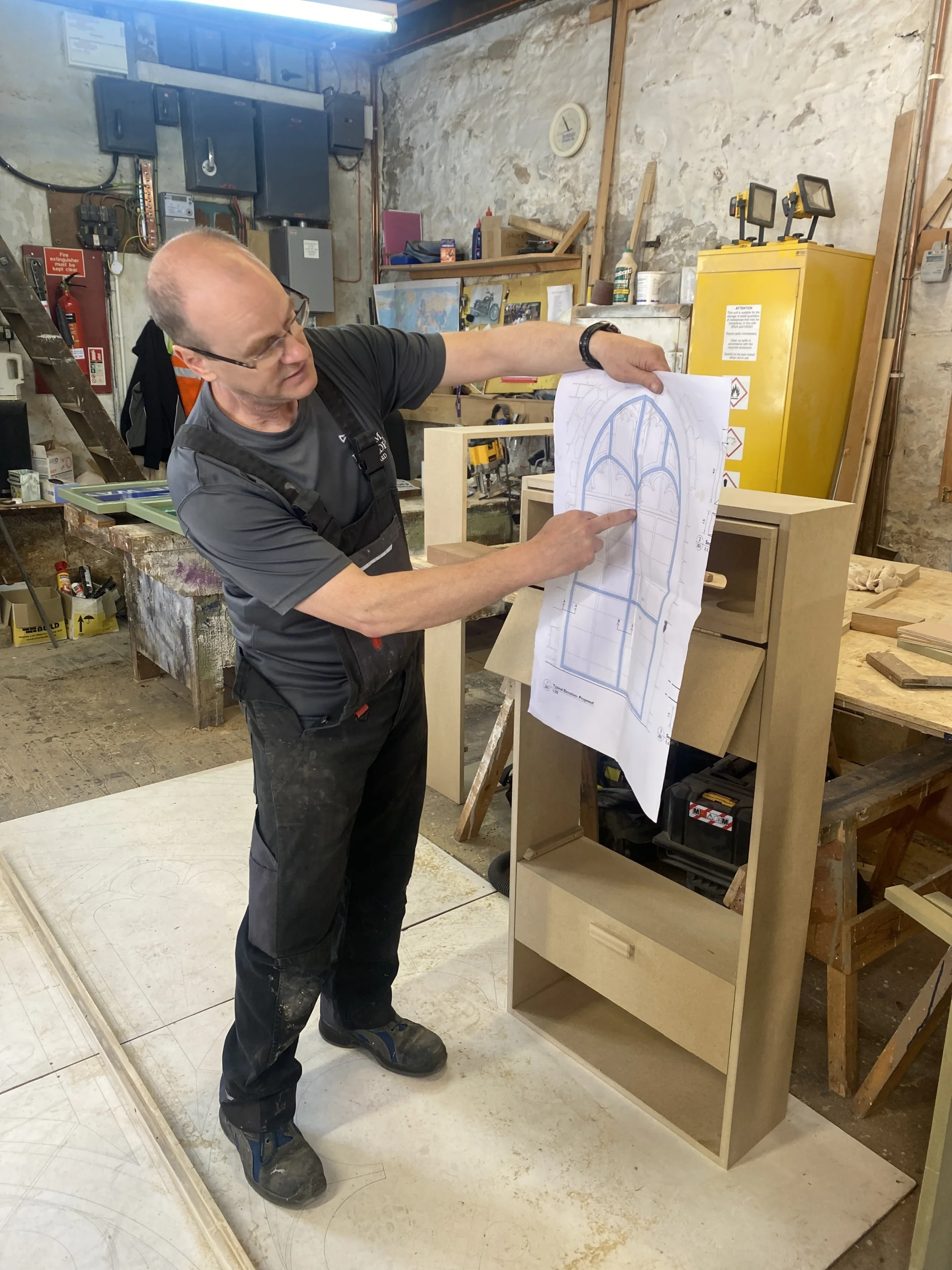 Swift boxes being made in workshop with builder holding up design plans to compare final box to the design